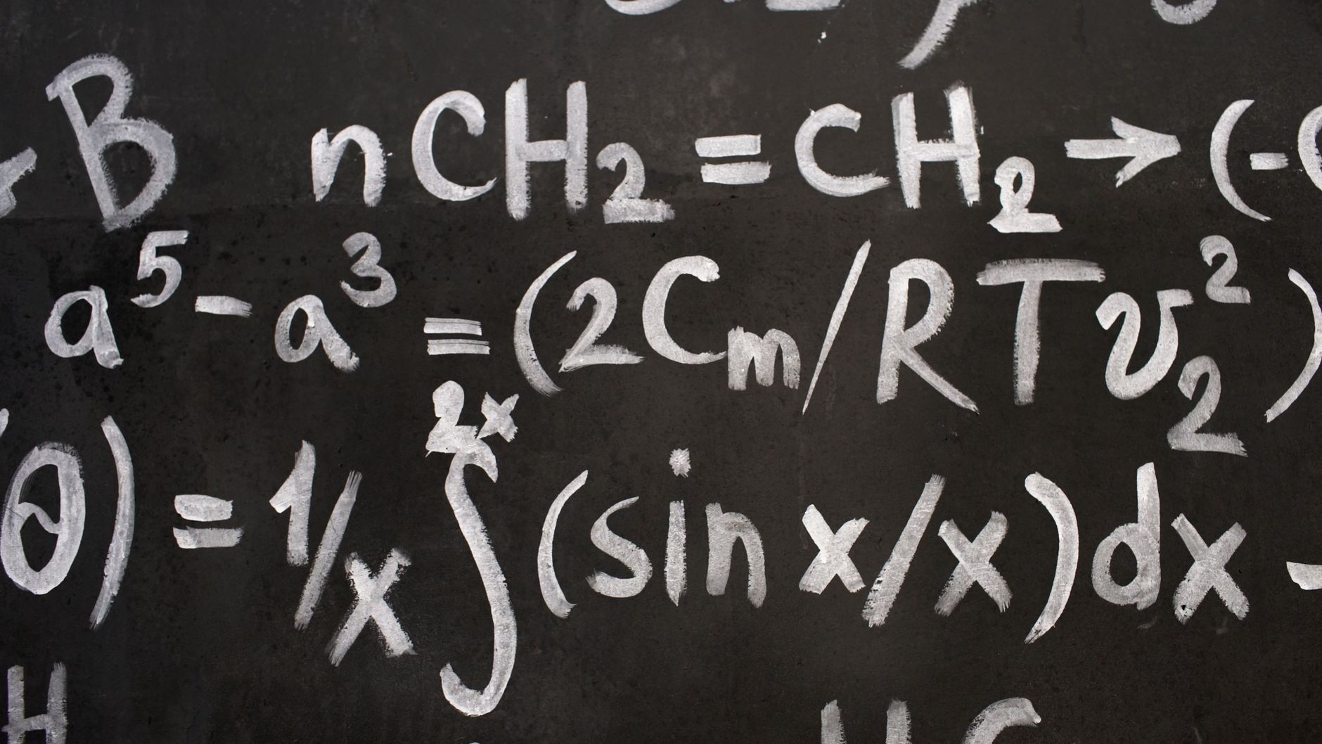 close up of complicated equations written on a blackboard